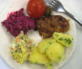 Clockwise from left: beet salad, pickled tomato, salt cucumber slice, pork chop, potatoes, potato salad.